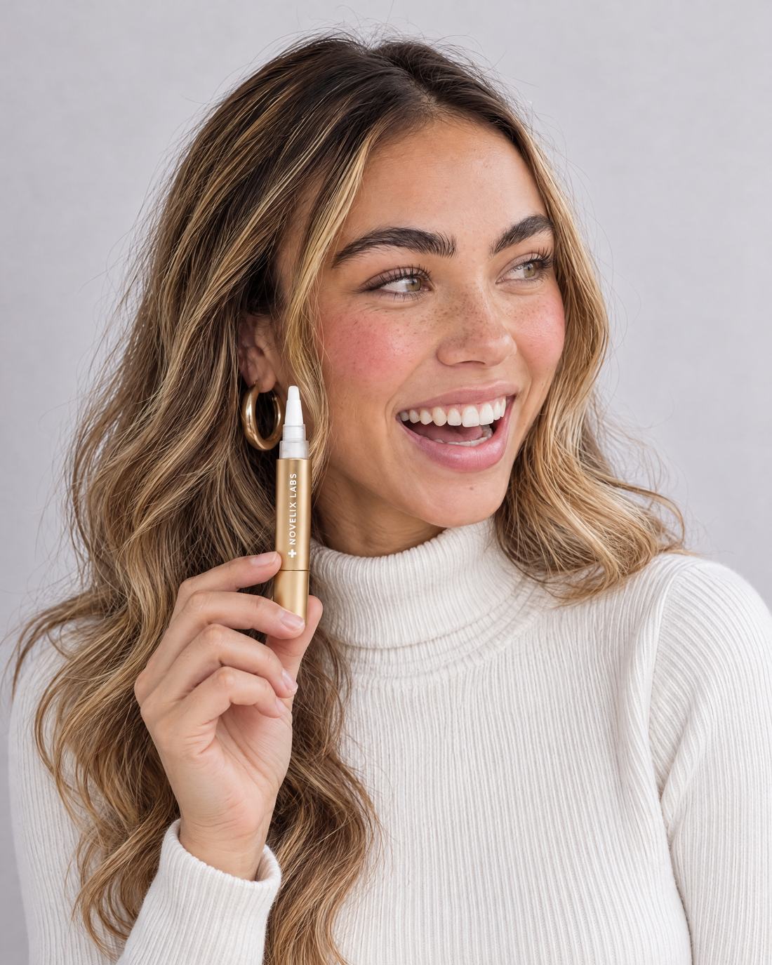 Customer smiling while holding the whitening pen